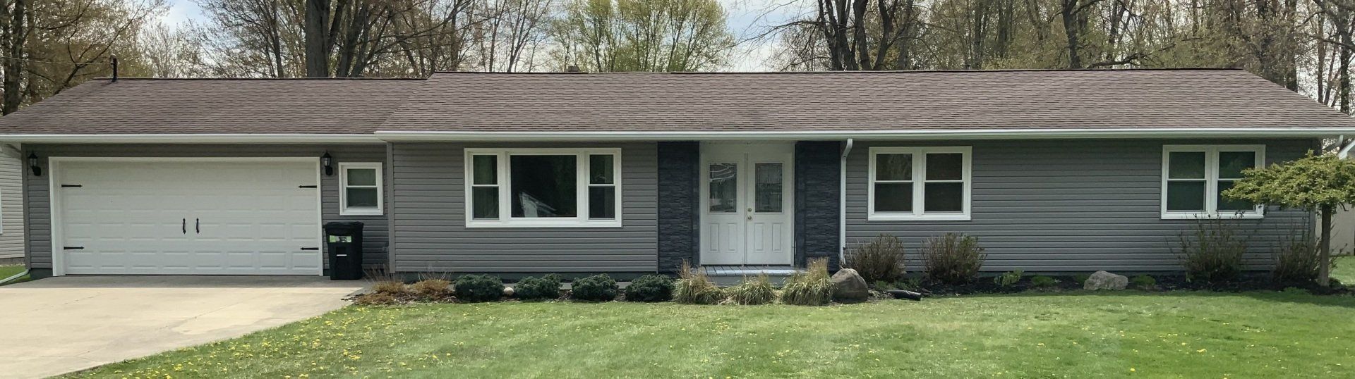 A gray house with a garage and a lot of windows