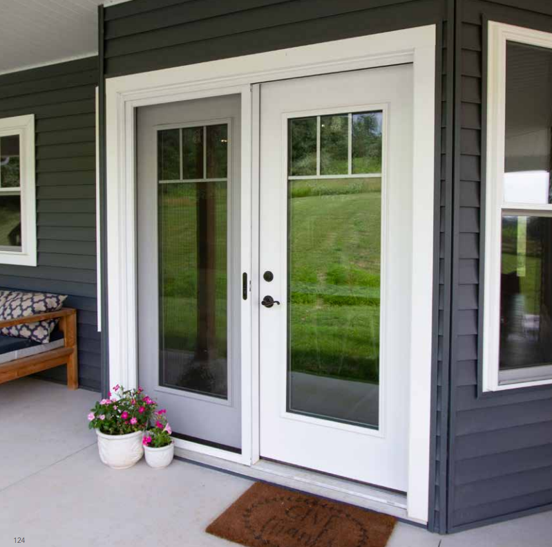A gray house with a white door and a welcome mat