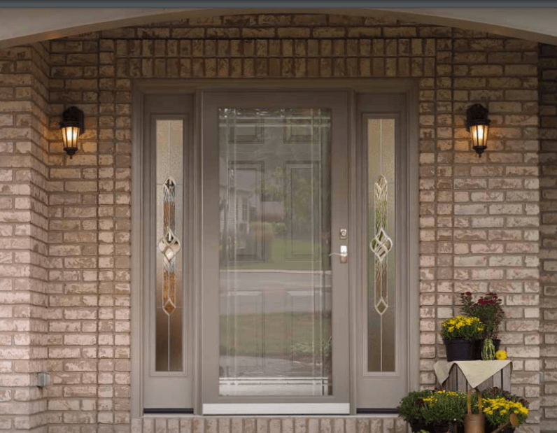 The front door of a brick house with flowers on the porch