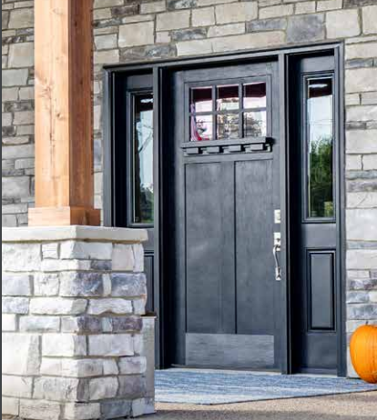 A black front door with a pumpkin in front of it