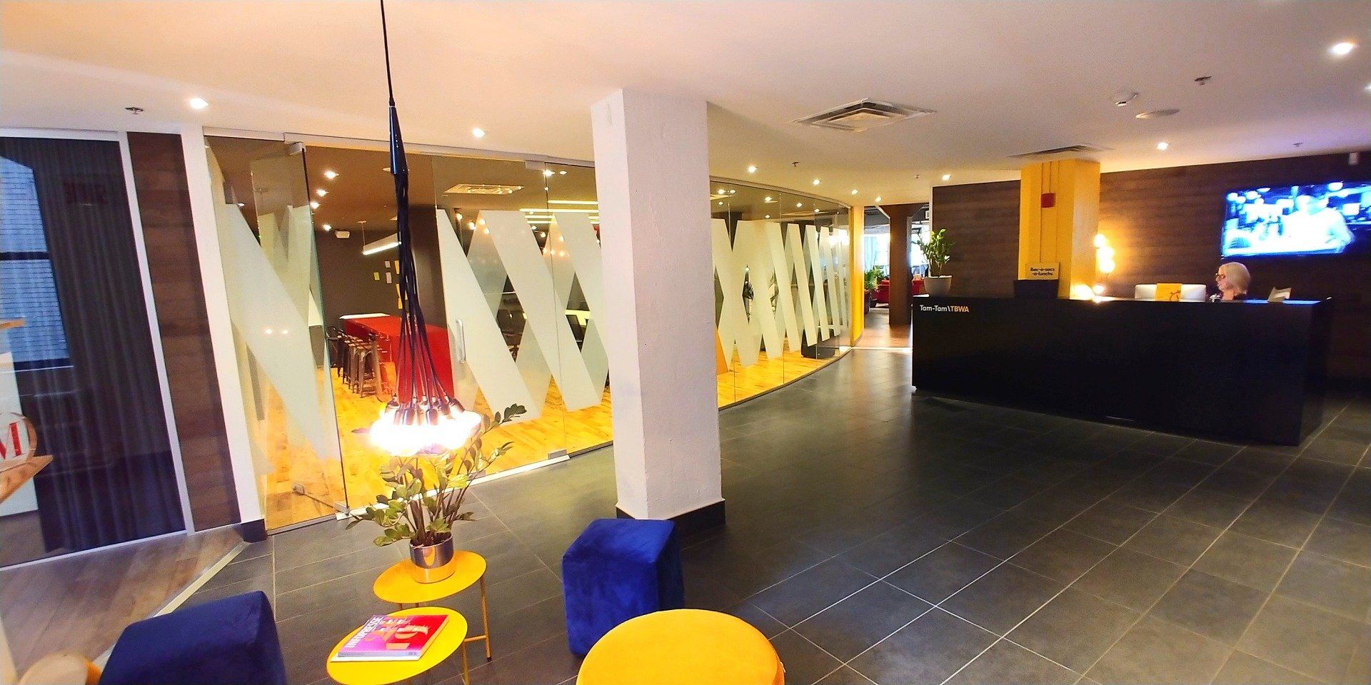 Un hall d'entrée d'un hôtel avec un homme derrière un comptoir