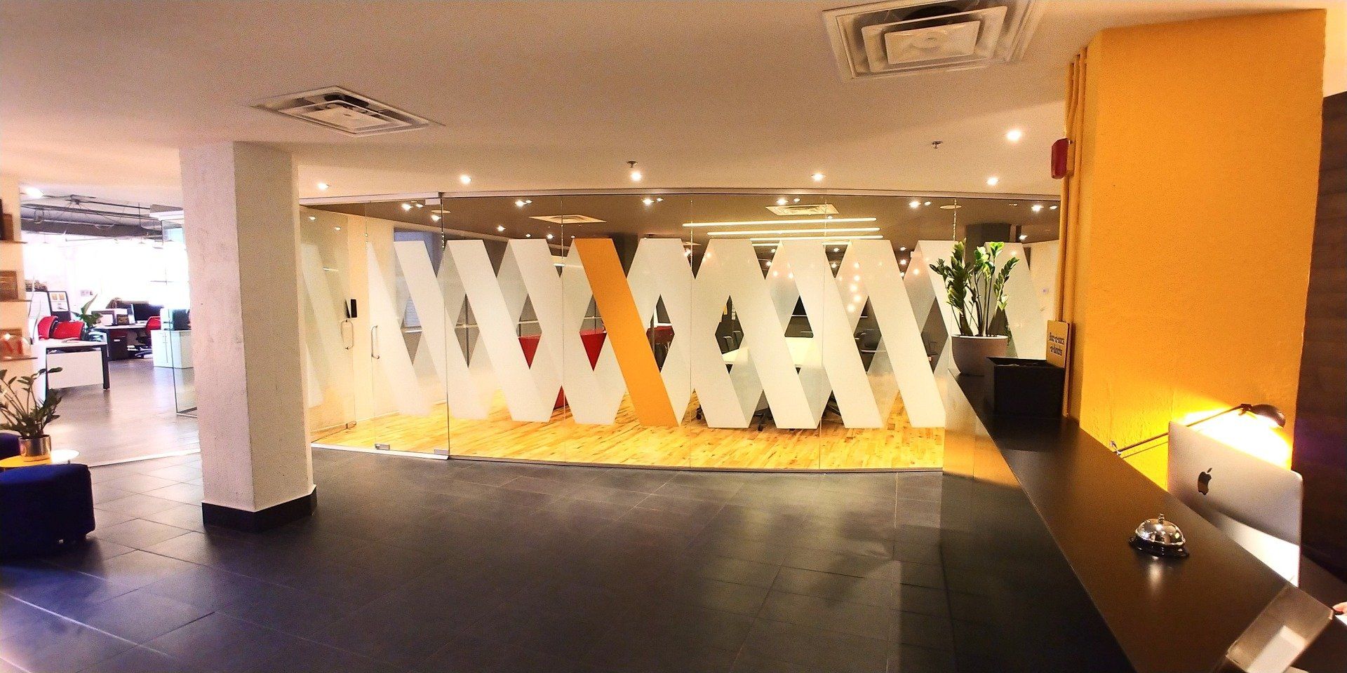 Un hall d'entrée avec un mur de verre sur lequel est écrit « www »