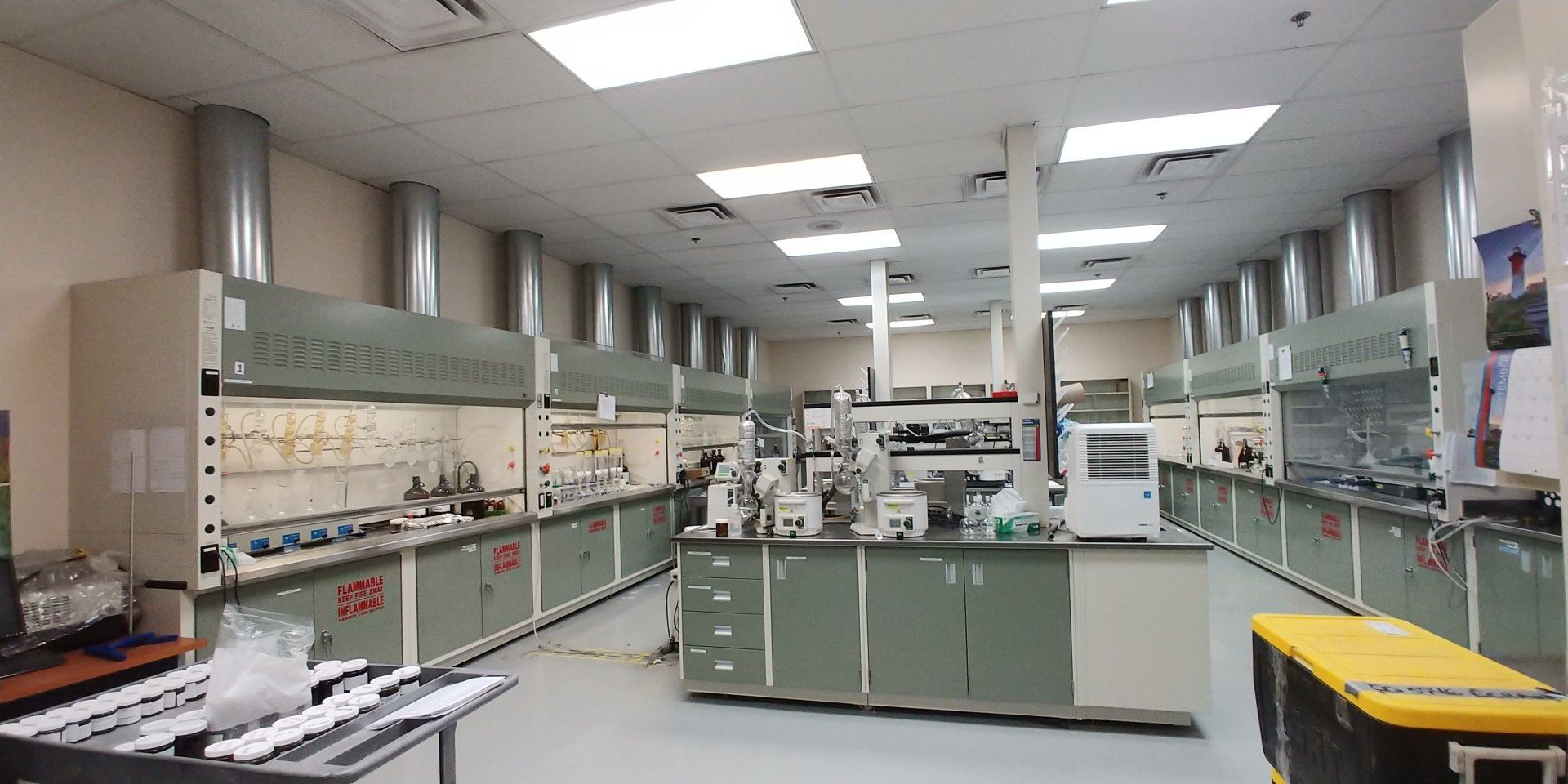 Un grand laboratoire avec beaucoup d'armoires et de hottes