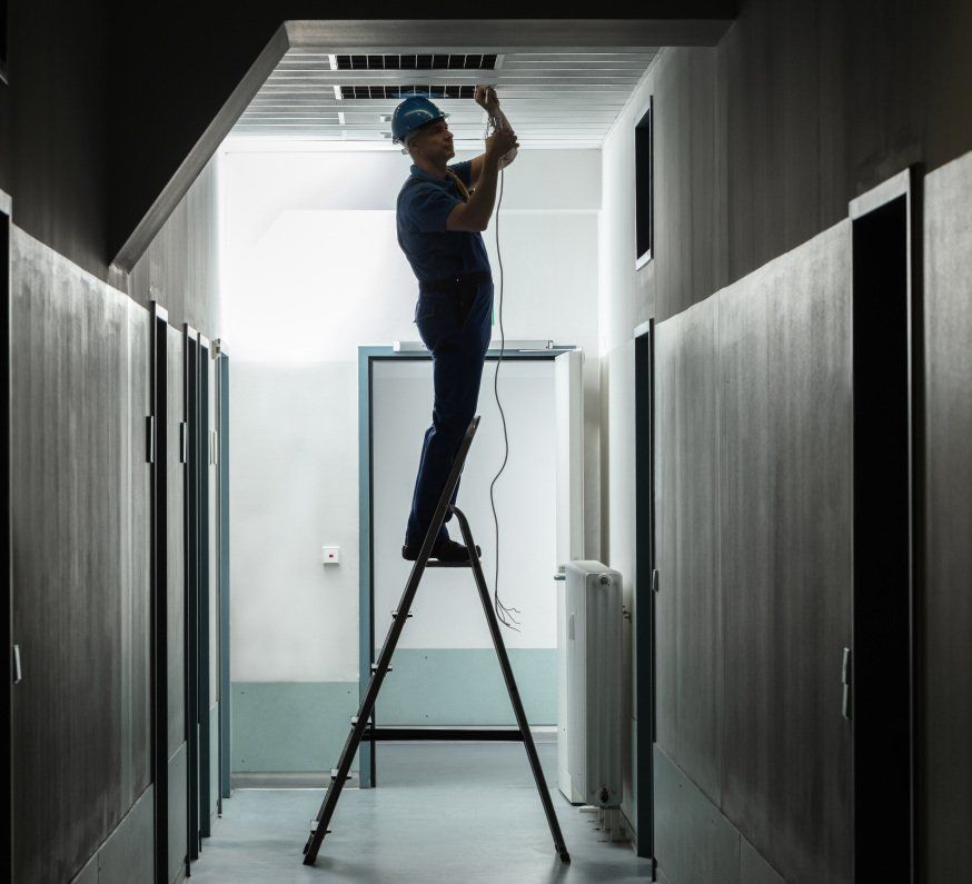 Un homme est debout sur une échelle dans un couloir
