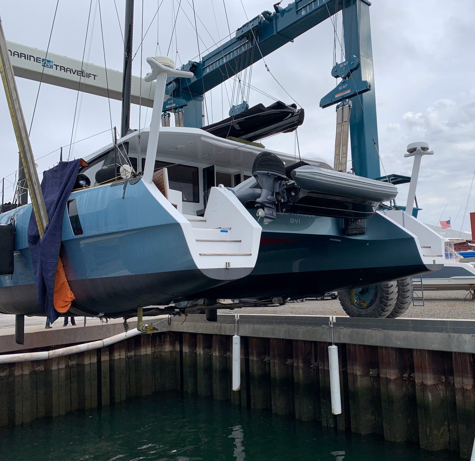 A boat is being lifted into the water by a crane