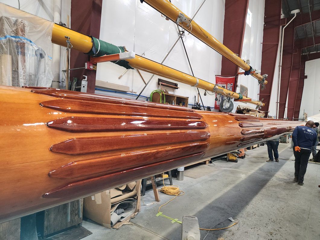 A man is standing next to a large wooden pole in a building.