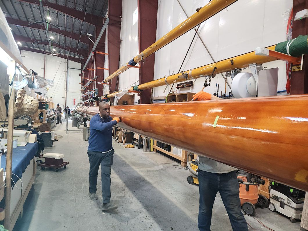 A man is holding a large piece of wood in a warehouse.