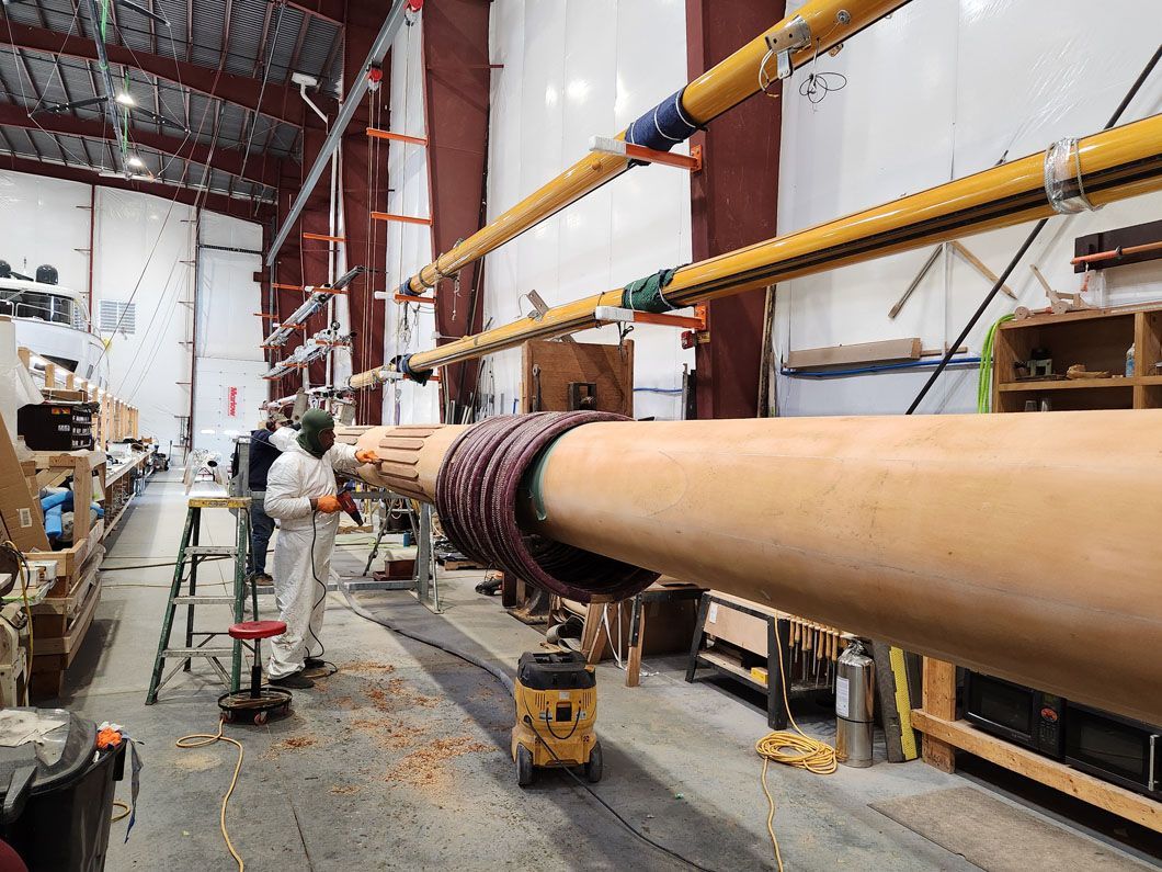 A man is standing next to a large pipe in a warehouse.
