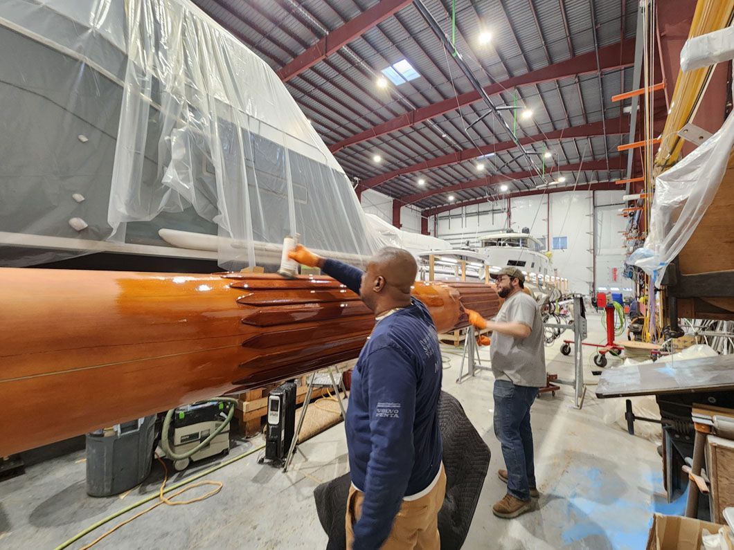 A group of men are working on a boat in a warehouse.