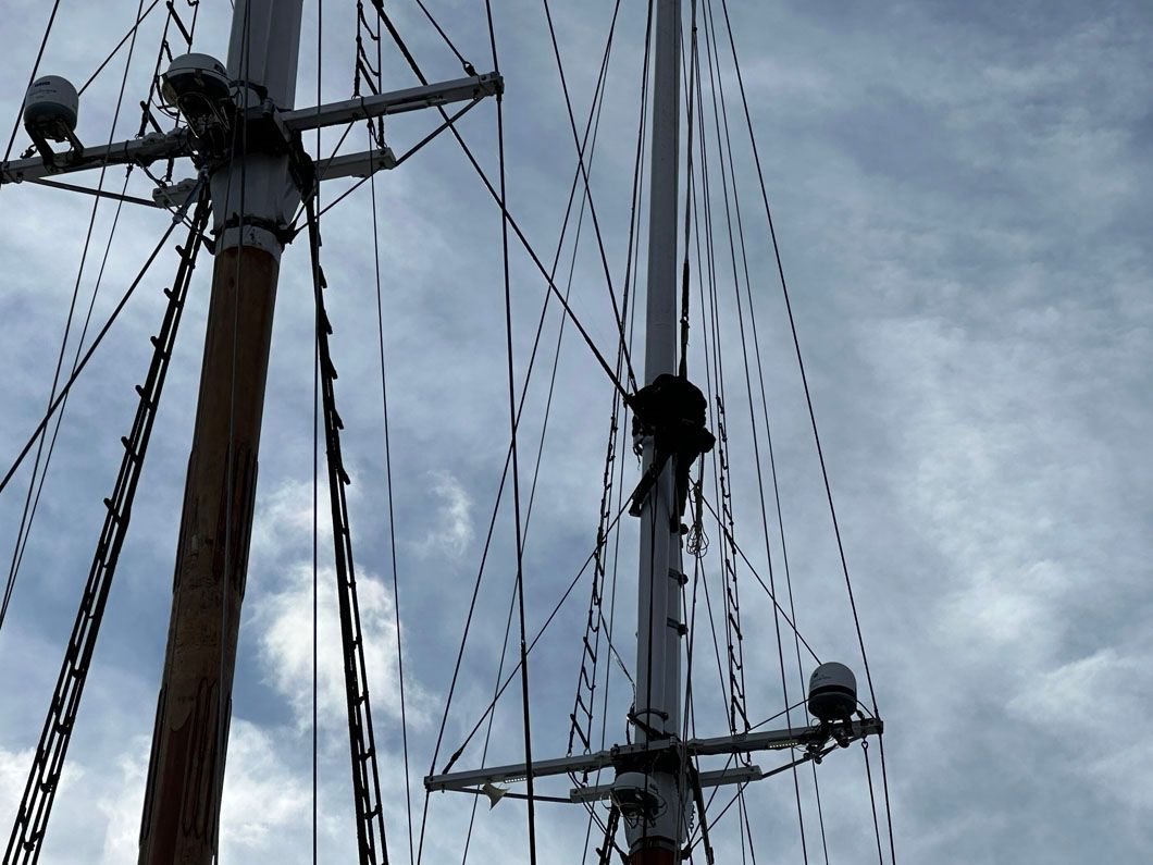 A sailboat mast with a blue sky in the background