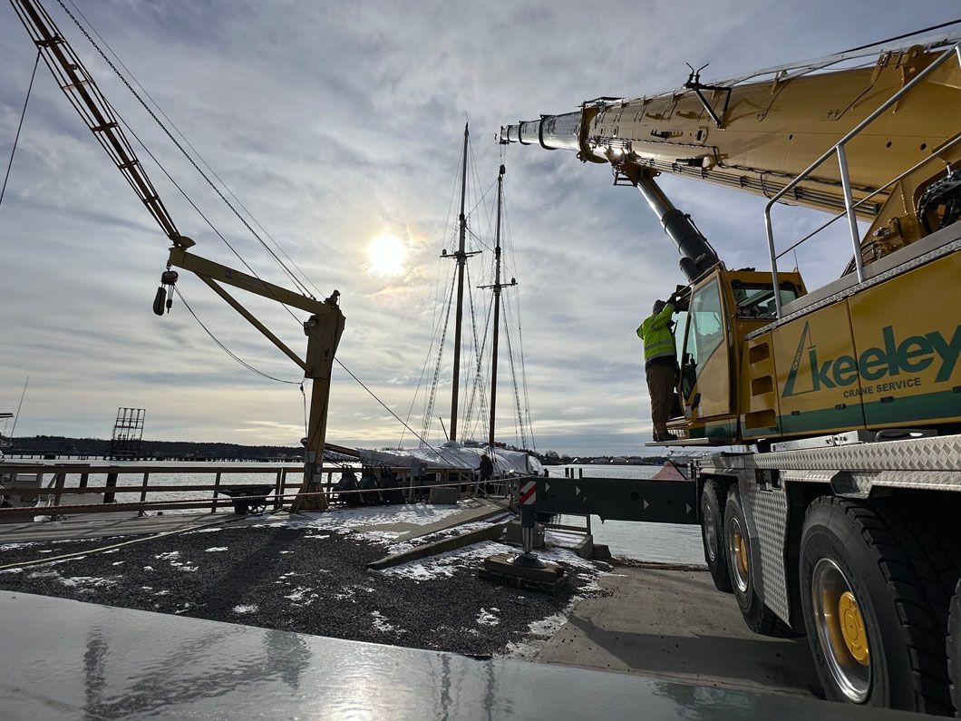 A crane is being used to lift a boat in the water.