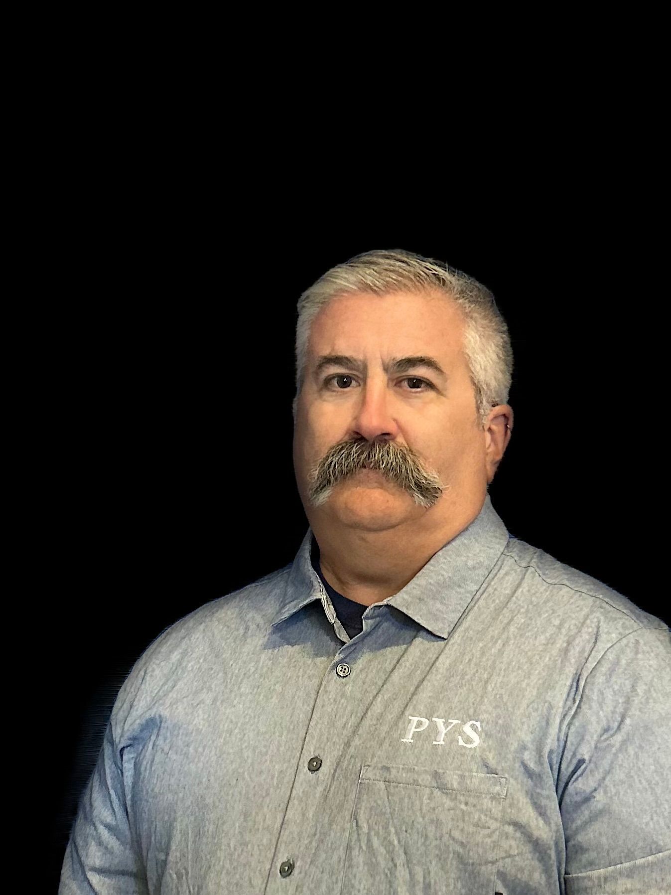 A man with a mustache is wearing a blue shirt.