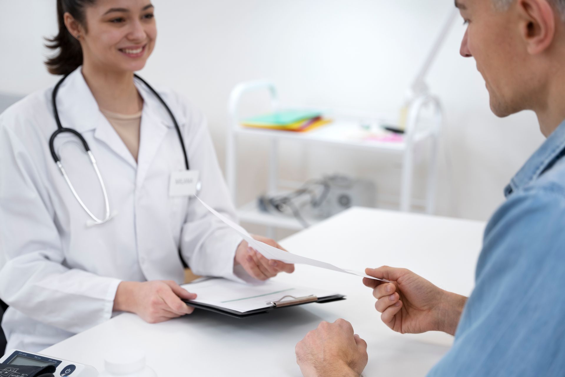 A doctor handing out a health risk assessment questionnaire to a patient during an annual wellness check-up