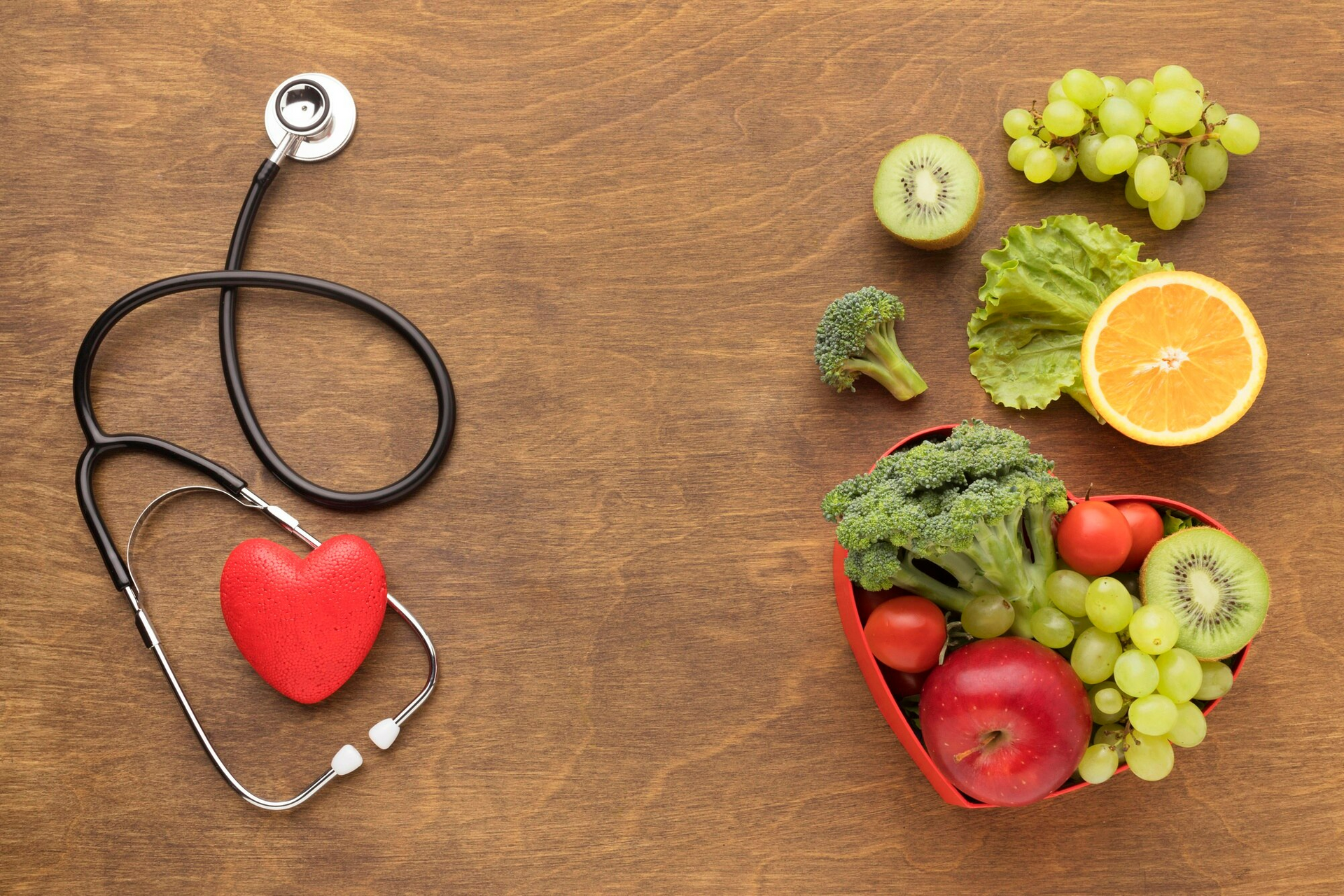 A heart-shaped bowl of fresh fruits and vegetables, symbolizing heart health.