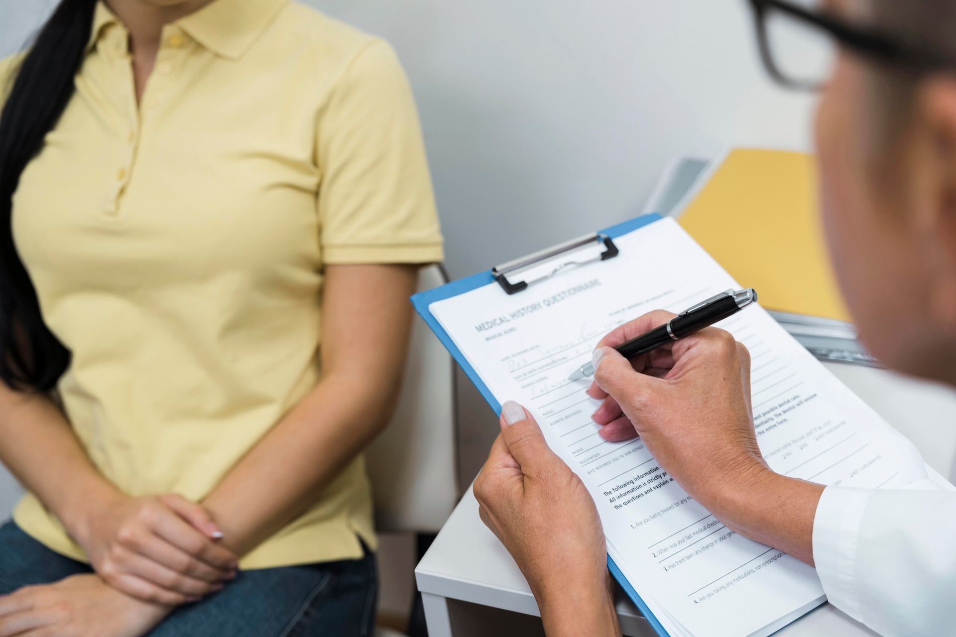 A doctor documents patient details as part of an annual wellness visit.