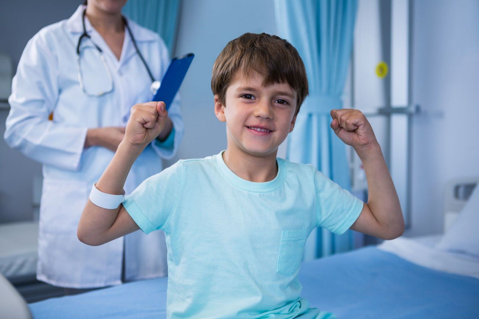 A child flexes his arms after a successful back-to-school health check at a trusted clinic for children’s exams.