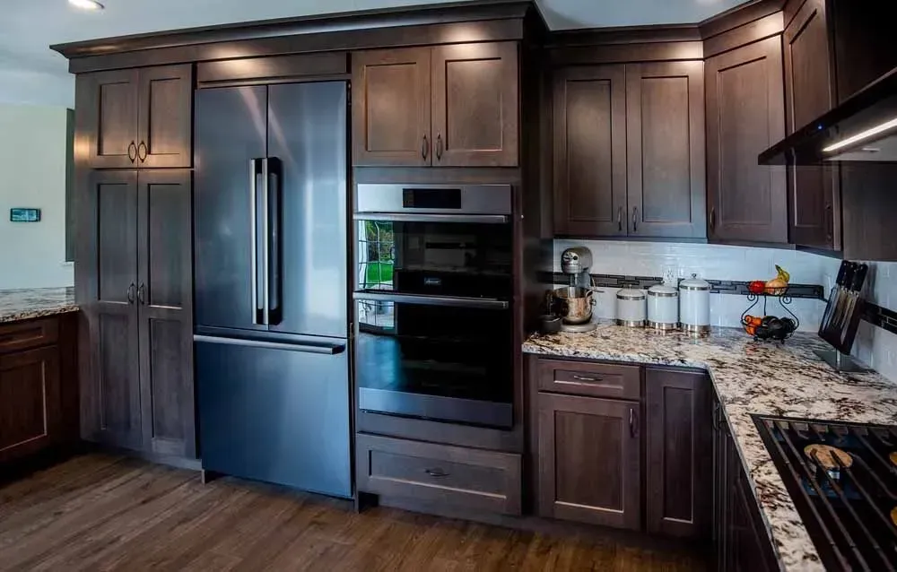 Kitchen with dark wood cabinets, stainless steel appliances, and granite countertops.