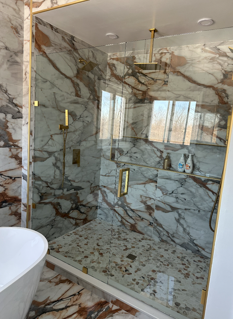 A bathroom with blue tiles and a sliding glass shower door.
