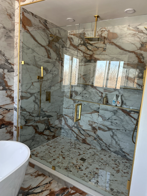 A bathroom with blue tiles and a sliding glass shower door.