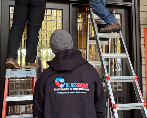 A bathroom with blue tiles and a sliding glass shower door.