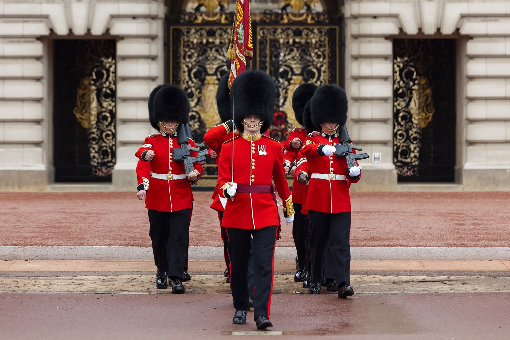 A group of soldiers marching in front of a building