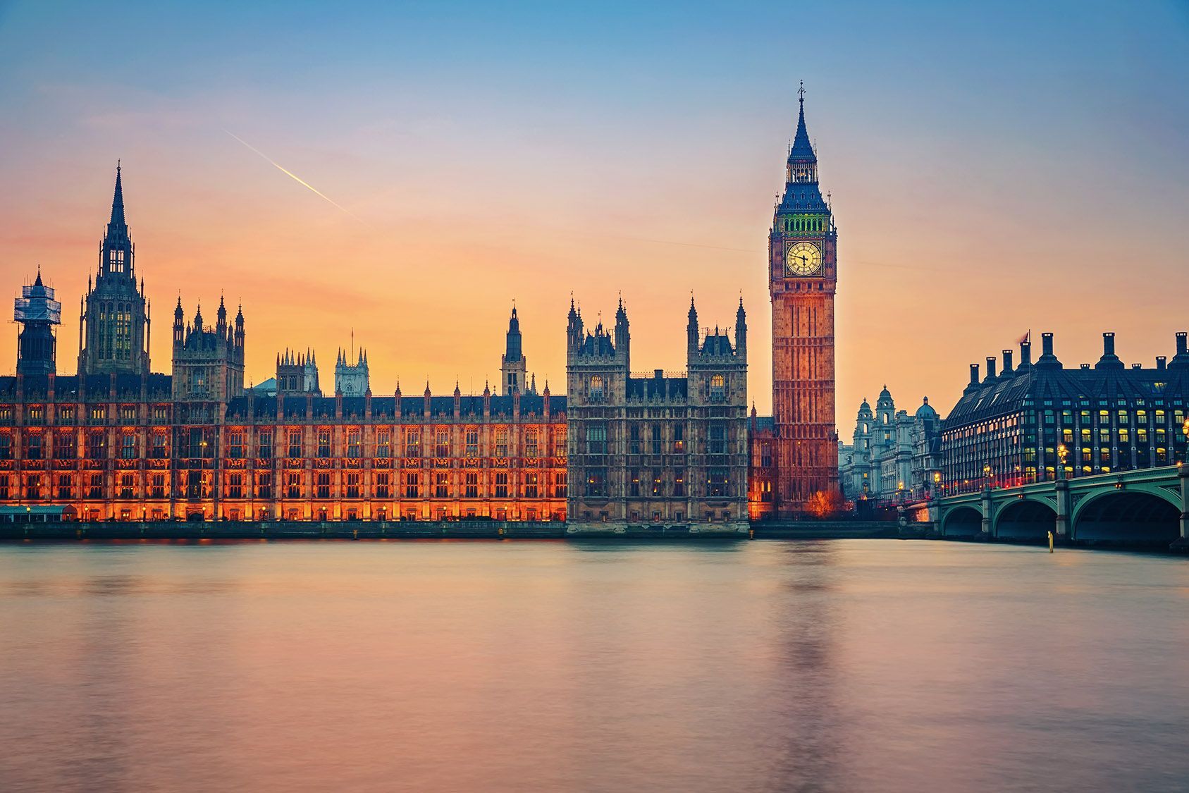 A view of the houses of parliament and big ben in london at sunset.