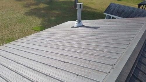 A wooden deck with a chimney on top of it.