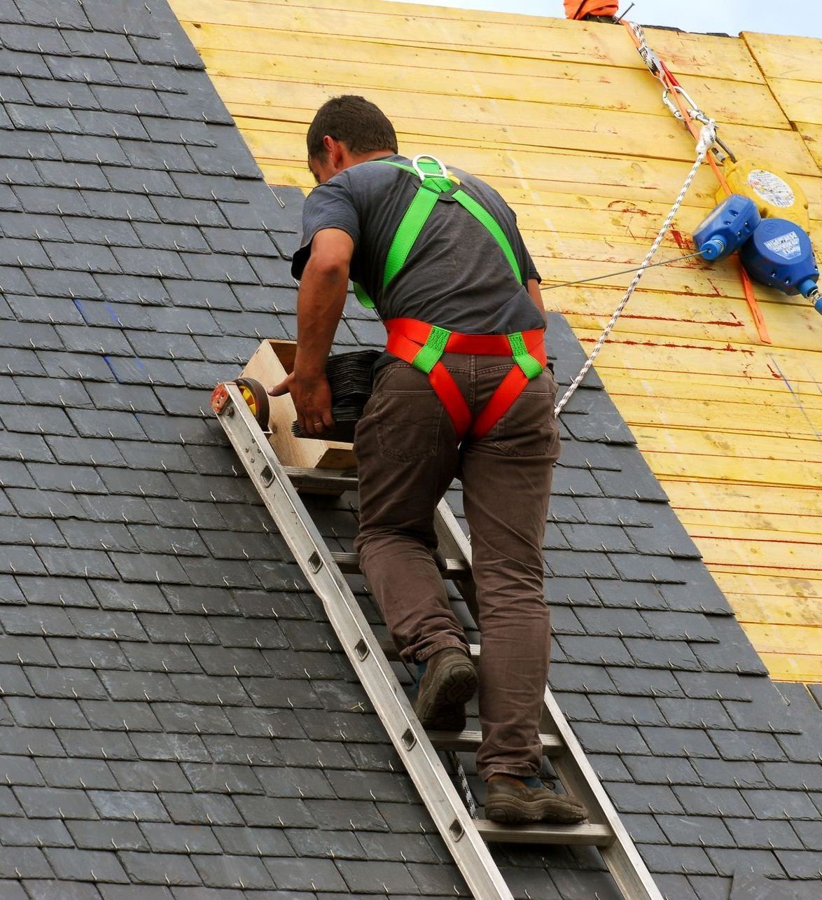 A man on a ladder working on a roof