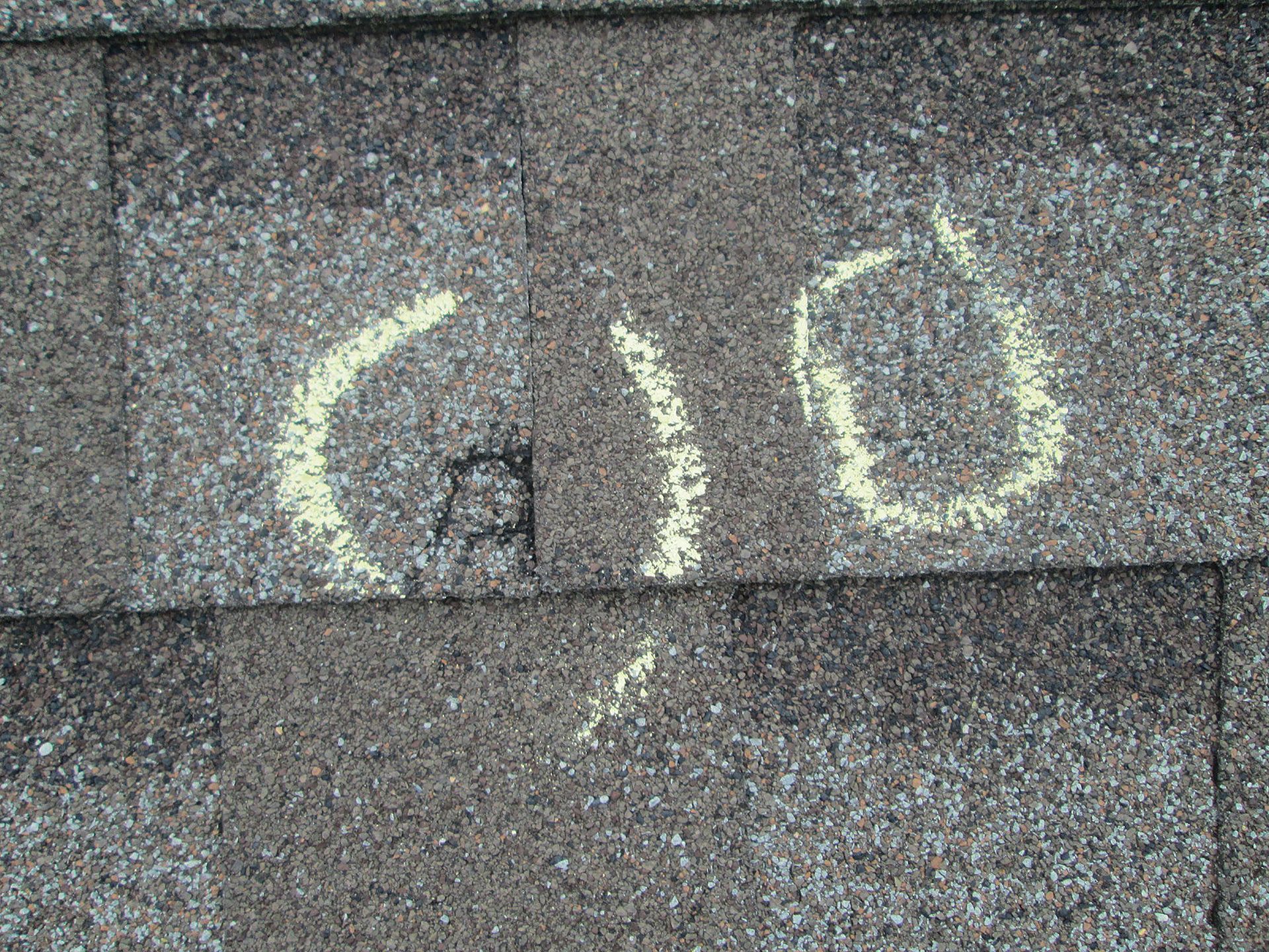 A close up of a roof with chalk written on it