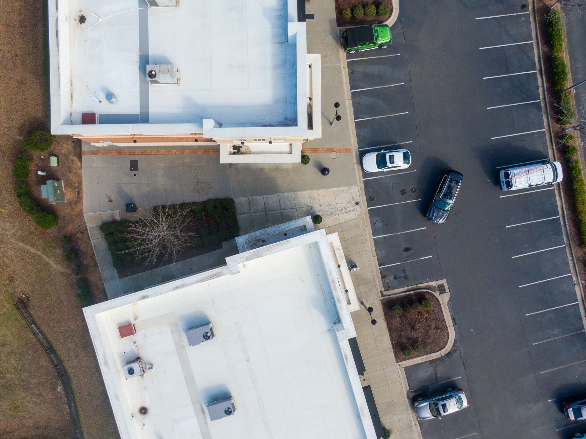 An aerial view of two buildings and a parking lot