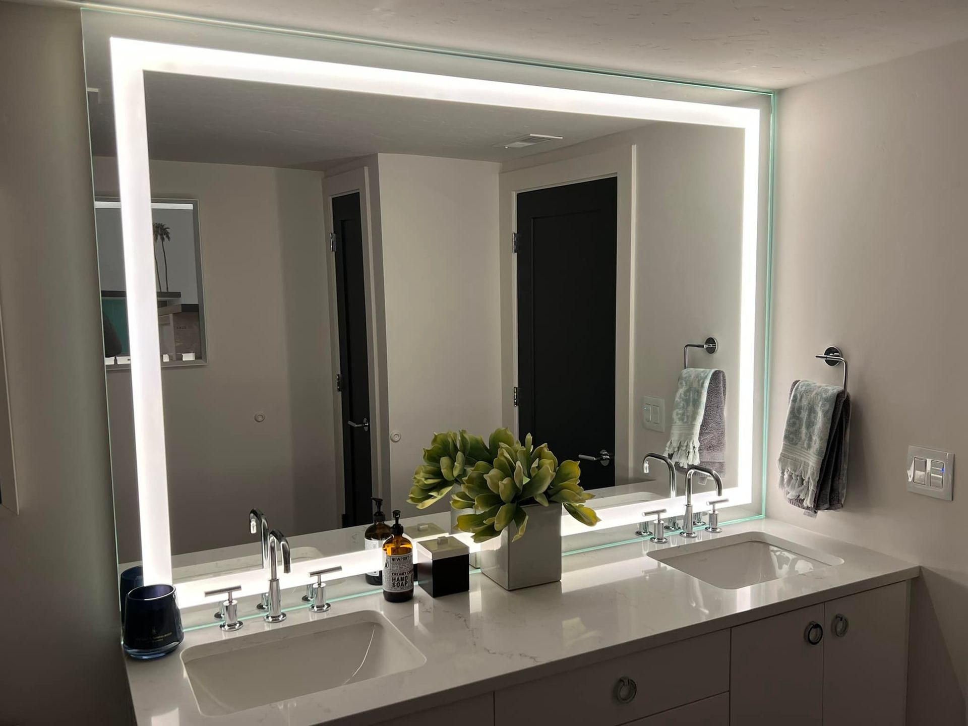 Modern bathroom with illuminated mirror above a double sink vanity.