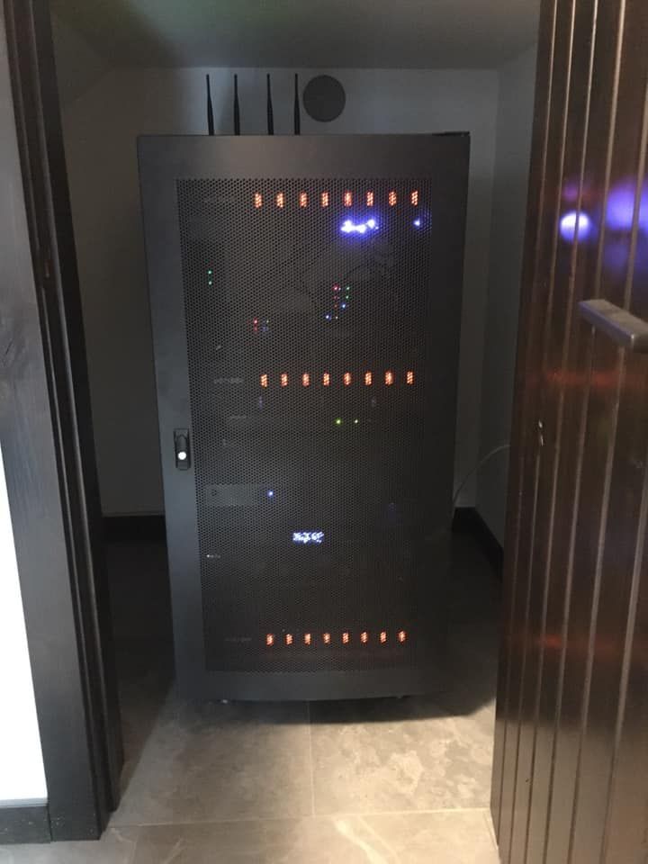 Black server rack in a doorway, with lights on and a keypad lock.