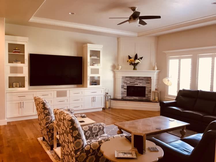 Living room with fireplace, built-in entertainment center, seating, hardwood floors, and windows.