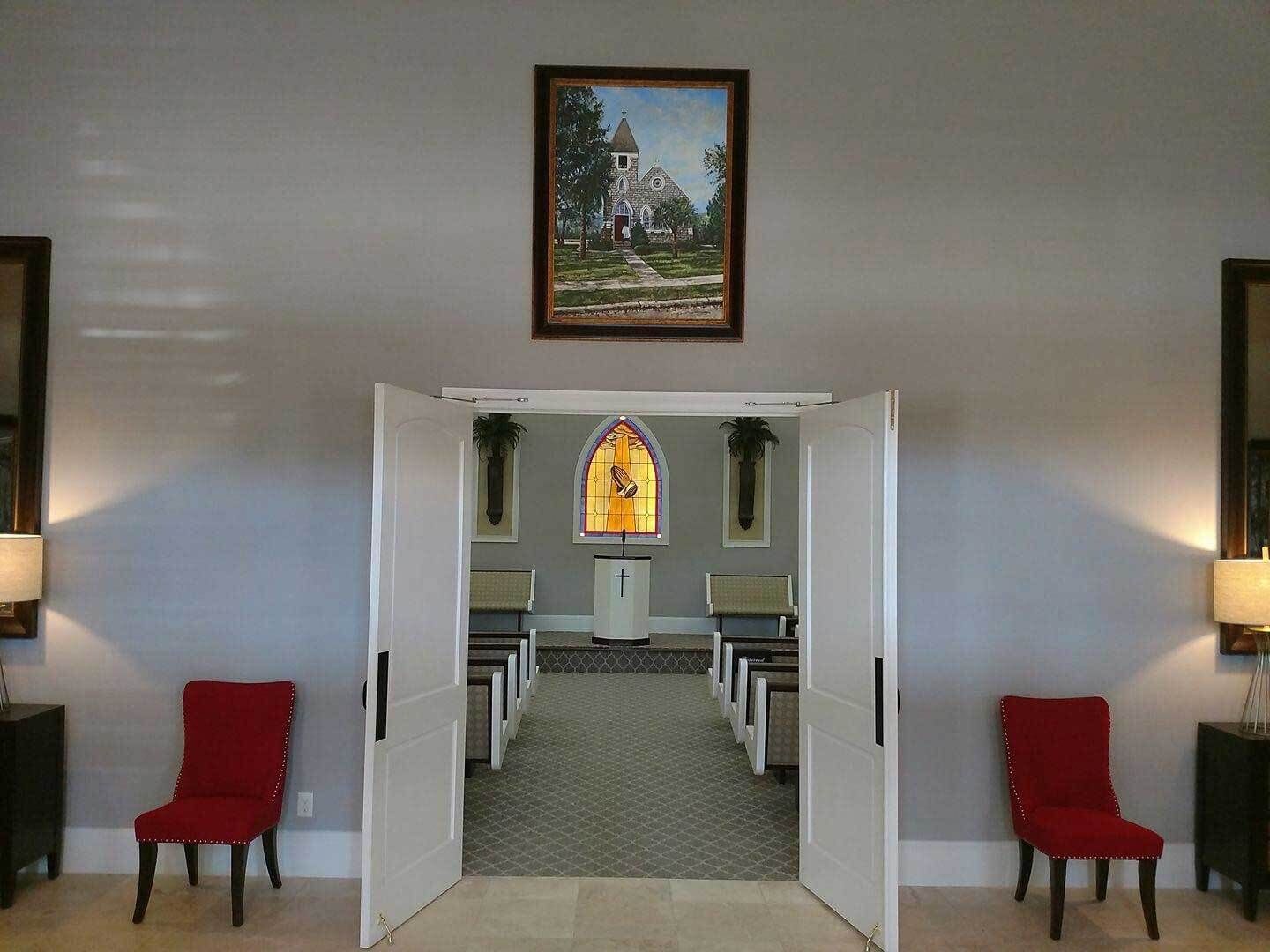 A man is standing in front of an open bible in a church.