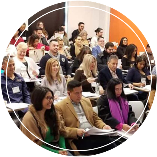 A group of people attending a classroom lecture, with diverse faces and expressions.
