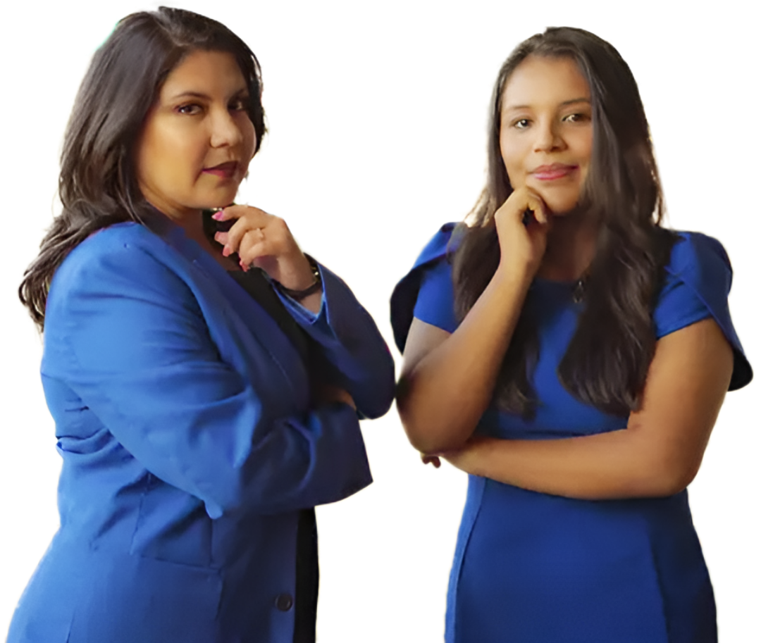 Two women in blue outfits, posing with their chins on their hands, looking at the viewer. White background.