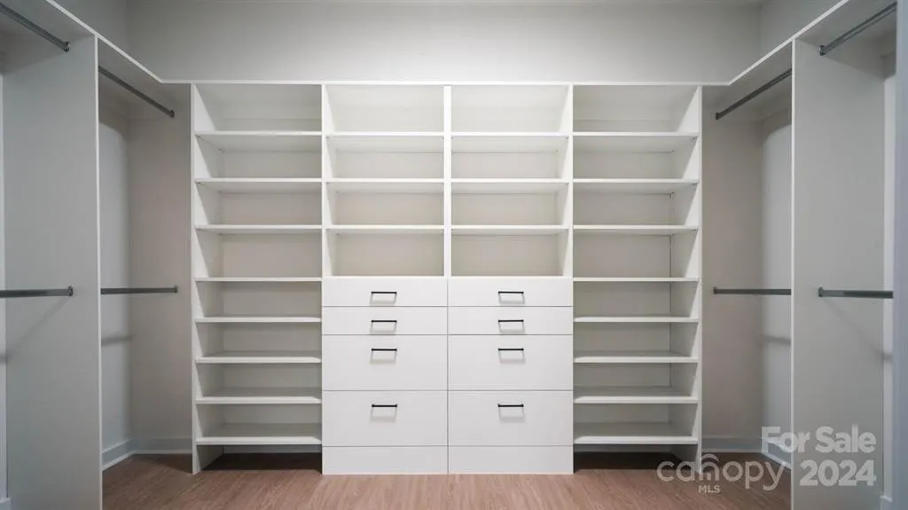 Empty white closet with shelves and drawers.