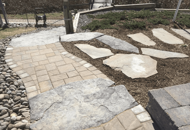 A walkway made of pavers and rocks in a garden.