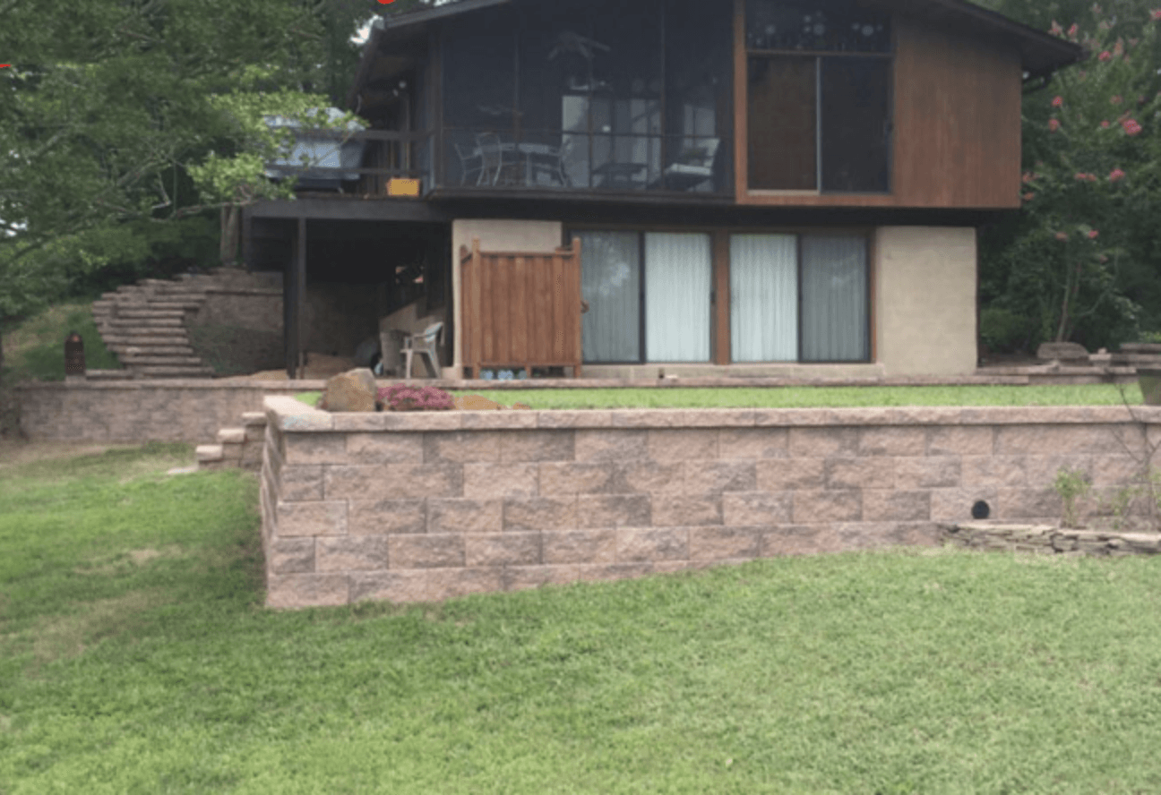 A large house with a retaining wall.