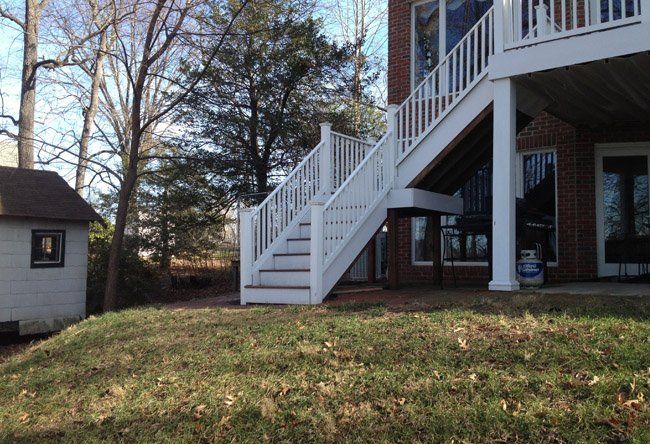 A white deck with stairs leading up to it