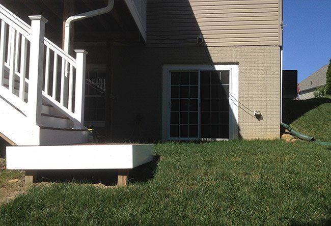The backyard of a house with a deck and stairs