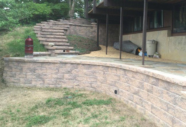 A brick wall with stairs leading up to a house.