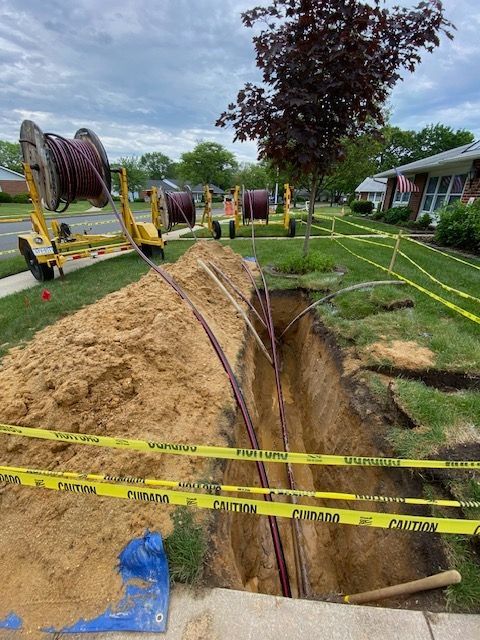 A hole in the ground with a bunch of wires coming out of it.
