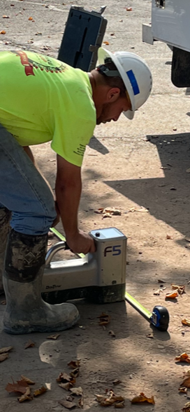 A man wearing a hard hat is working with a locator F5.