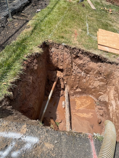 A large hole in the ground with a hose in it.