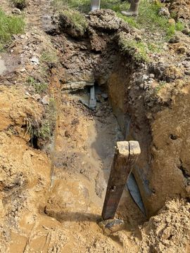 A hole in the ground with a wooden post in it.