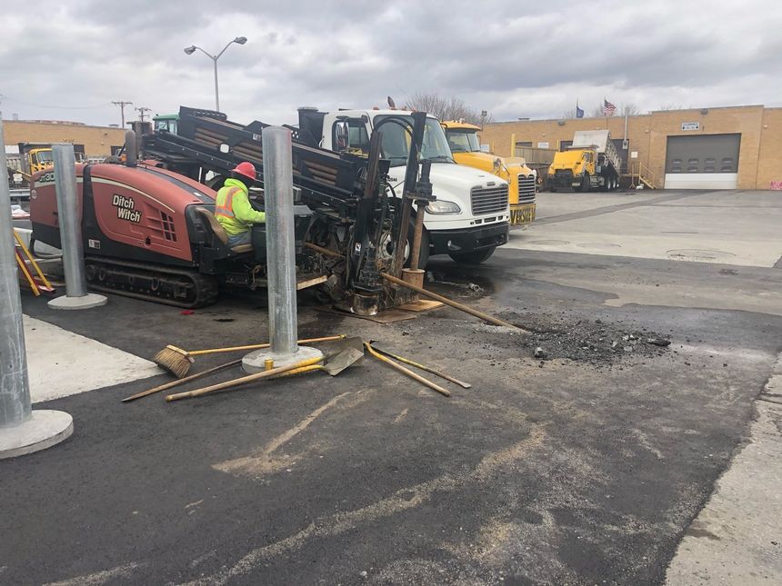 A man is working on a machine in a parking lot.