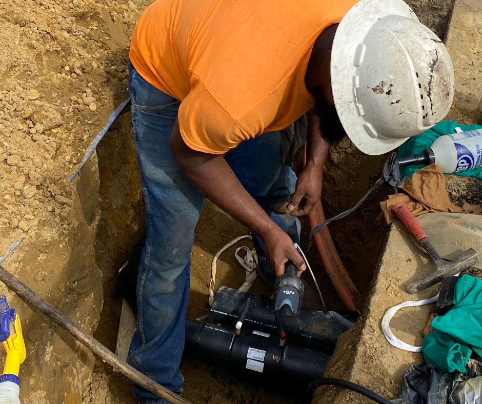 A DVUC crewmember is fusing pipes to carry communication lines. 