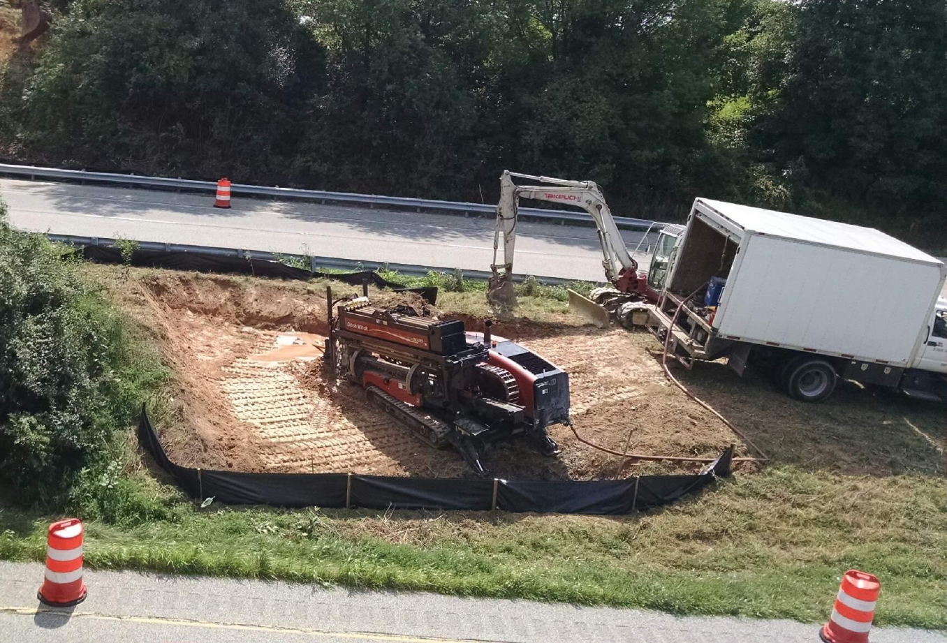 A white truck is parked on the side of the road next to a construction site