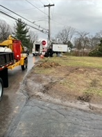 A truck is driving down a road next to a field.